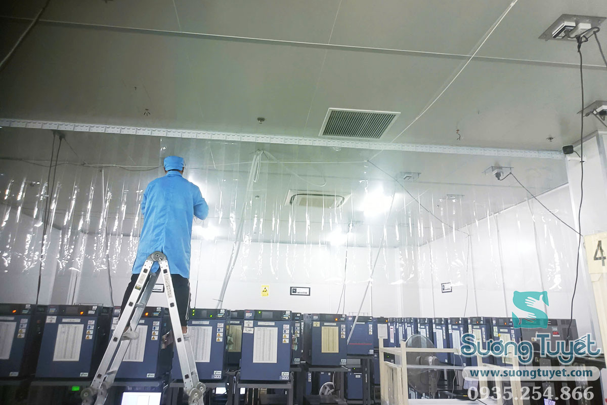 Thợ rèm Sương Tuyết đứng trên thang bắt thanh ray rèm PVC lên trần nhà xưởng
