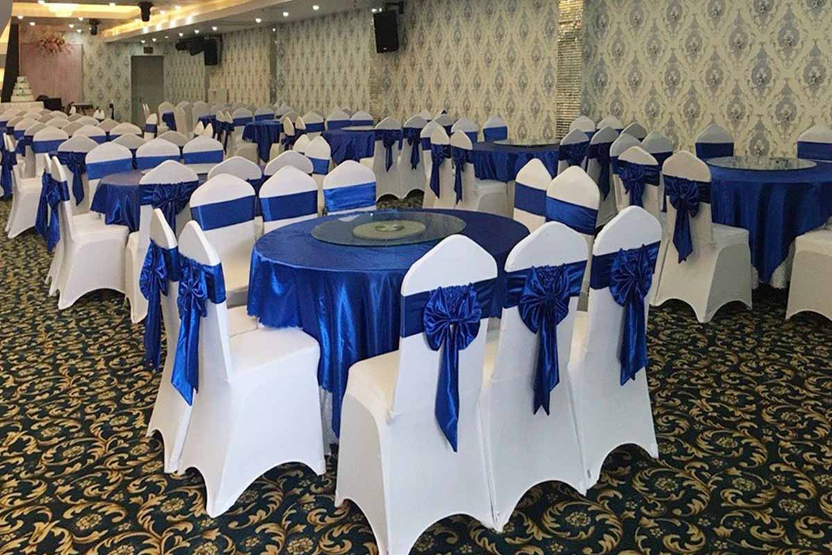 Một ví dụ khá đẹp khi dùng khăn bàn và nơ ghế xanh hòa cùng áo ghế thun trắng hiện đại.