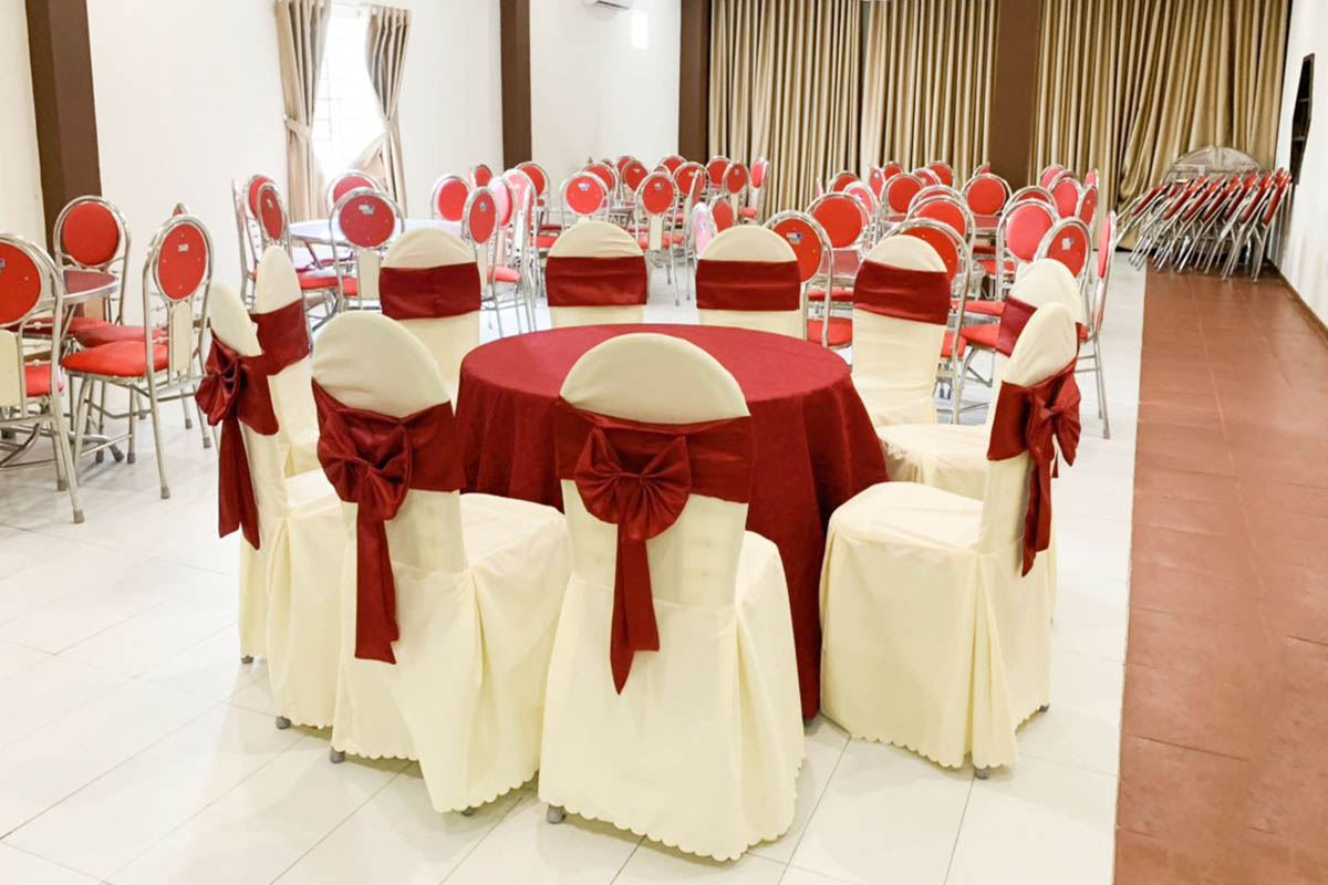Nghệ thuật phối áo ghế màu trắng kem sạch sẽ và khăn bàn đỏ rực rỡ