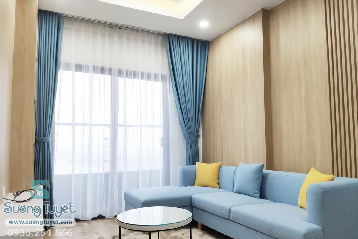 Phòng khách rực sáng trong tông rèm vải xanh.