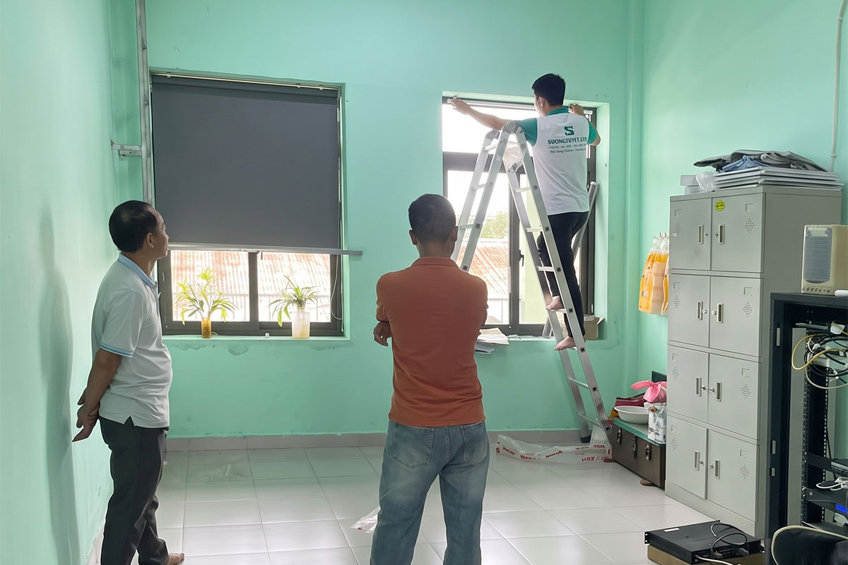 Nhân viên Sương Tuyết hoàn tất việc lắp rèm dưới sự theo dõi của khách.