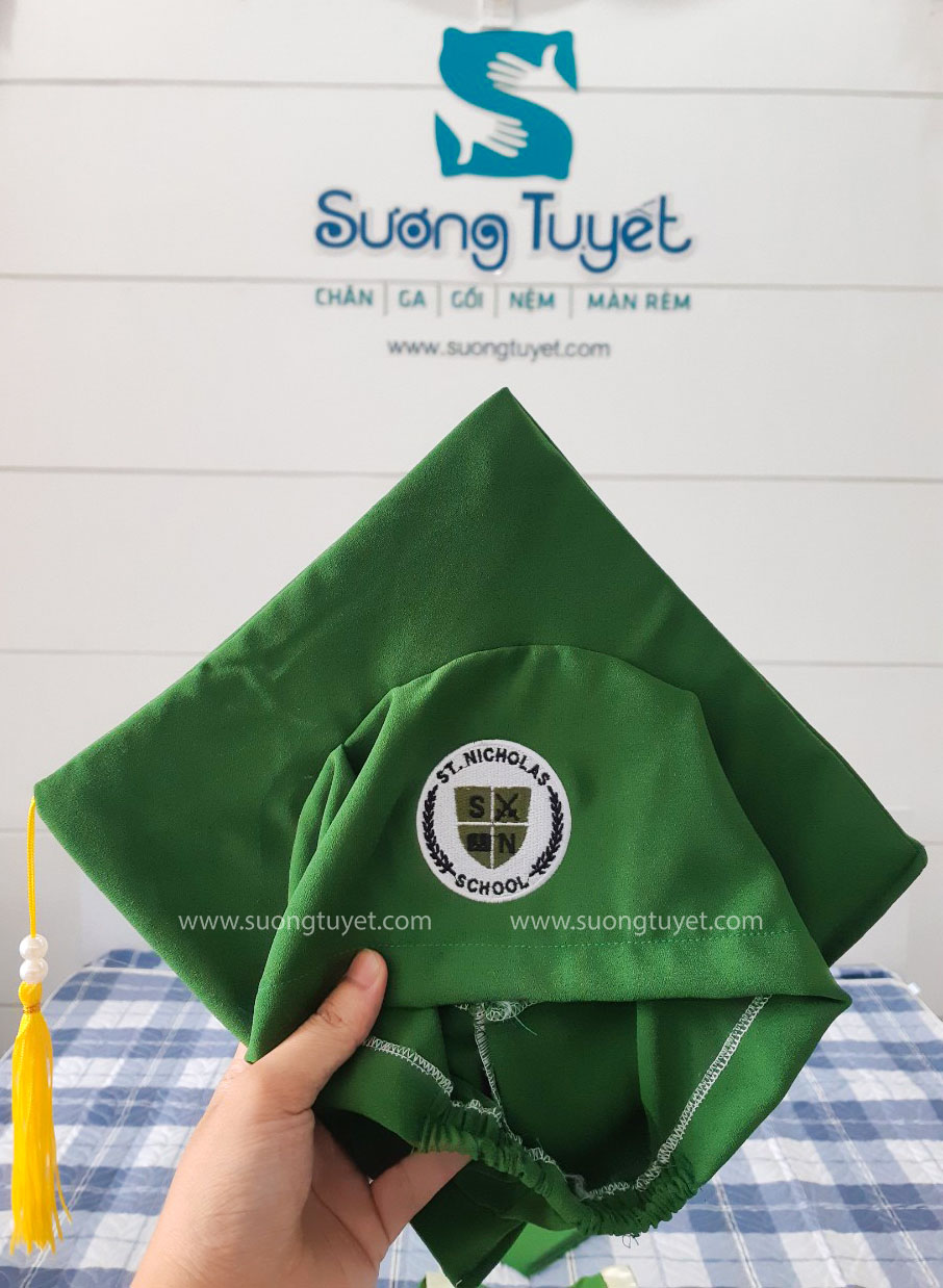 Nón tốt nghiệp được Sương Tuyết thêu logo của trường nổi bật trên nền xanh